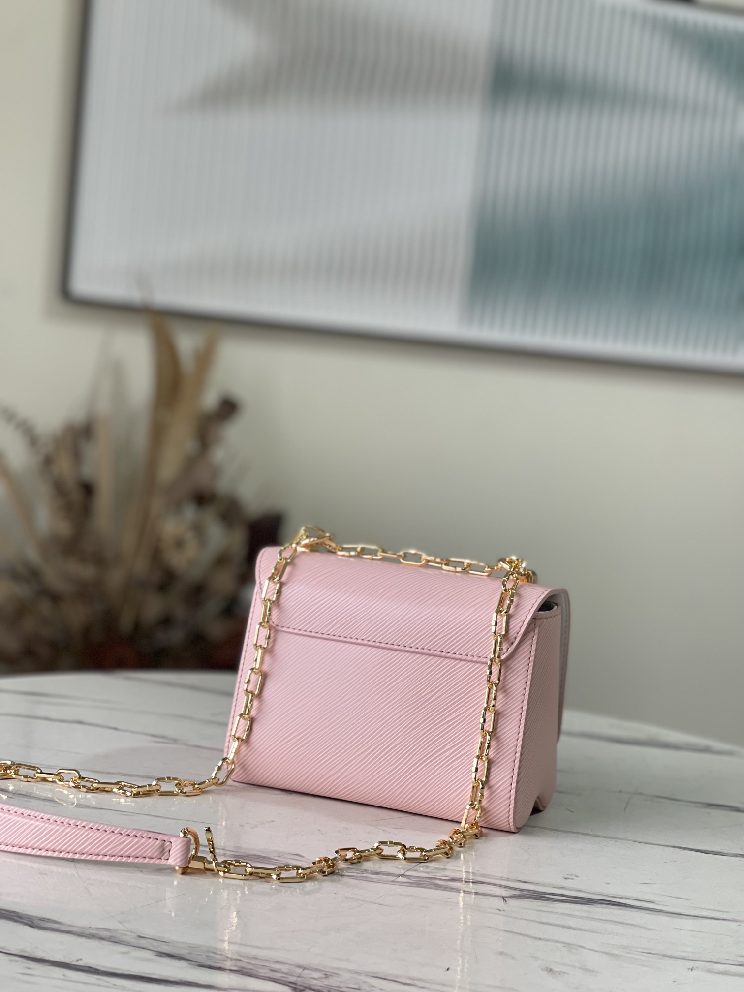 M21027 Pink Shuttle Lock 50332 Pink Shuttle Lock This Twist small handbag is made of Epi leath