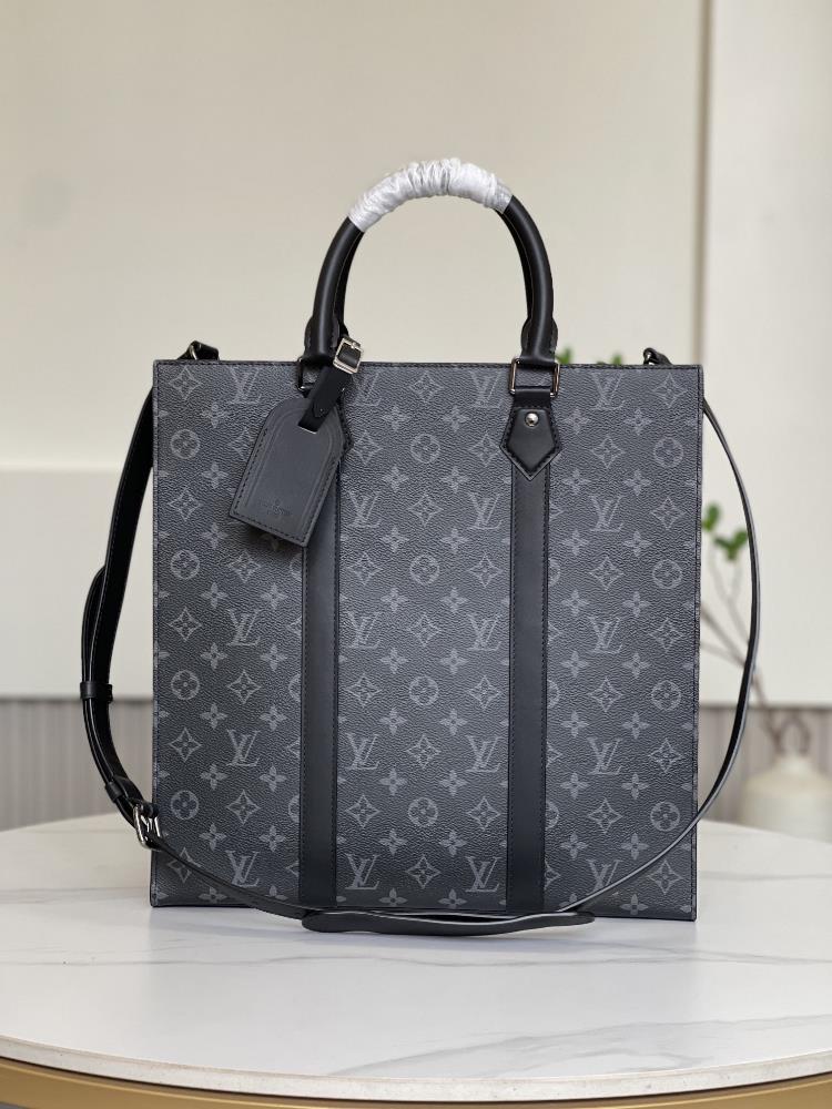 M46452 This Sac Plat handbag is crafted with Monogram Eclipse coated canvas to create a slender configuration paired with wide ribbons showcasing a