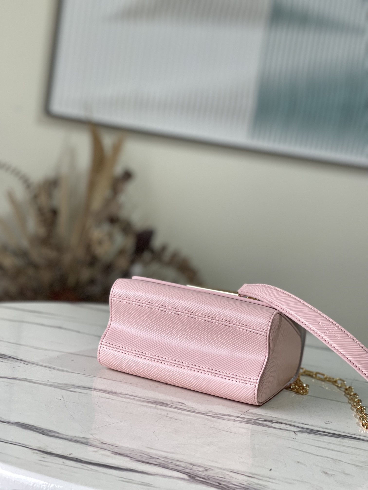 M21027 Pink Shuttle Lock 50332 Pink Shuttle Lock This Twist small handbag is made of Epi leath