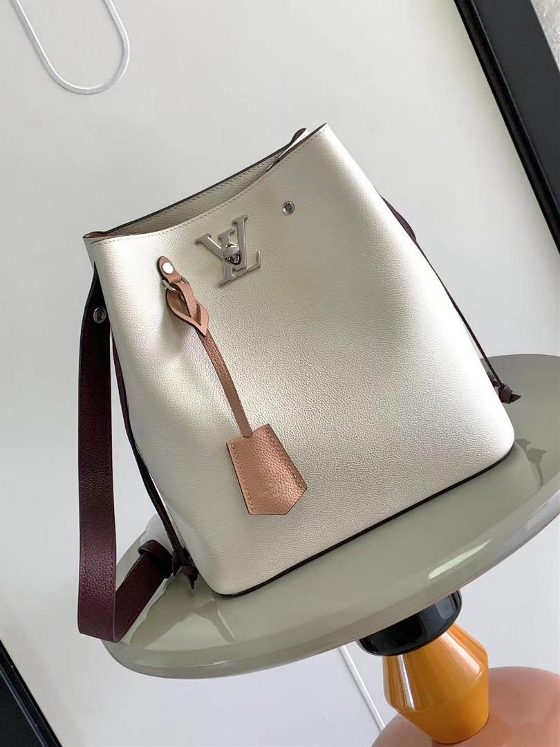 M54677s latest water bucket bag features imported soft calf leather with a shiny twist lock closure